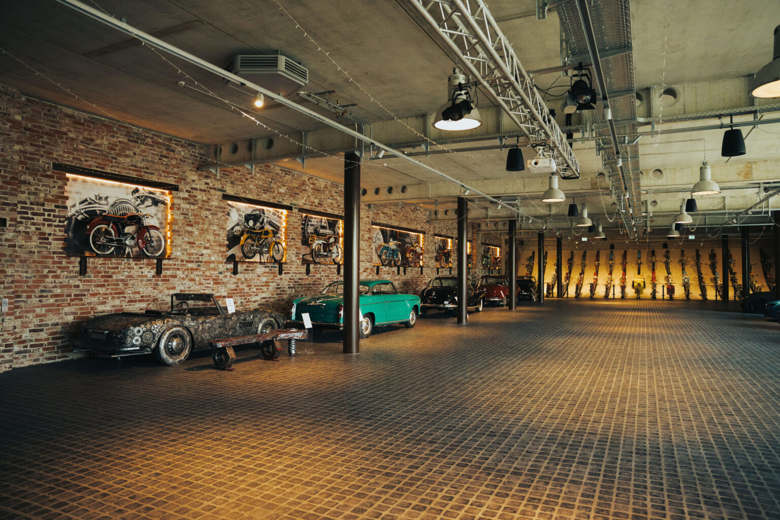 Die Ausstellungshalle mit hinterleuchteter Ziegelwand