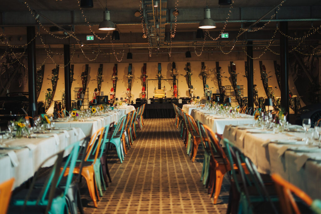 Festlich gedeckte lange Tafel bei einem Firmenevent zwischen Oldtimern